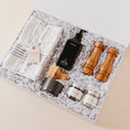 Load image into Gallery viewer, Lavender and Pine Kitchen Essentials Gift Box angle view featuring Monaco kitchen towels, Homecourt Cece dish soap, dish brush set, Natural OliveWood salt and pepper mills, and La Boite Tellicherry pepper and grey salt in white magnetic gift box