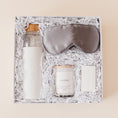 Load image into Gallery viewer, Lavender and Pine Rest and Restore Gift Box featuring Soma glass water bottle, Pure Sol silk sleep mask, Roote lavender candle, and Shinery radiance towelettes in white luxe two piece gift box