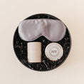 Load image into Gallery viewer, Lavender and Pine Ultimate Bliss Gift Box featuring Pure Sol silk sleep mask, Minot candle, and Harney and Sons Vanilla Comoro tea tin in black round gift box