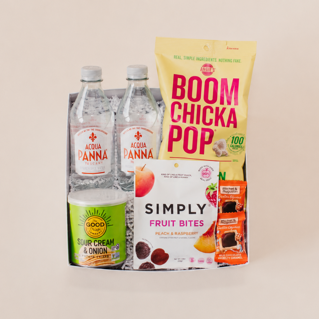 Bright Welcome Collection gift box with Acqua Panna water, Angie's Boom Chicka Pop, The Good Crisp Company chips, Simply Fruit Bites, and Michel et Augustin cookies, curated by Lavender + Pine Gifting