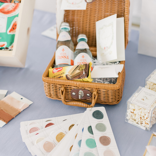 DIY wedding welcome gift basket with still water, snacks, and itinerary card styled by Lavender + Pine for a personalized guest experience.