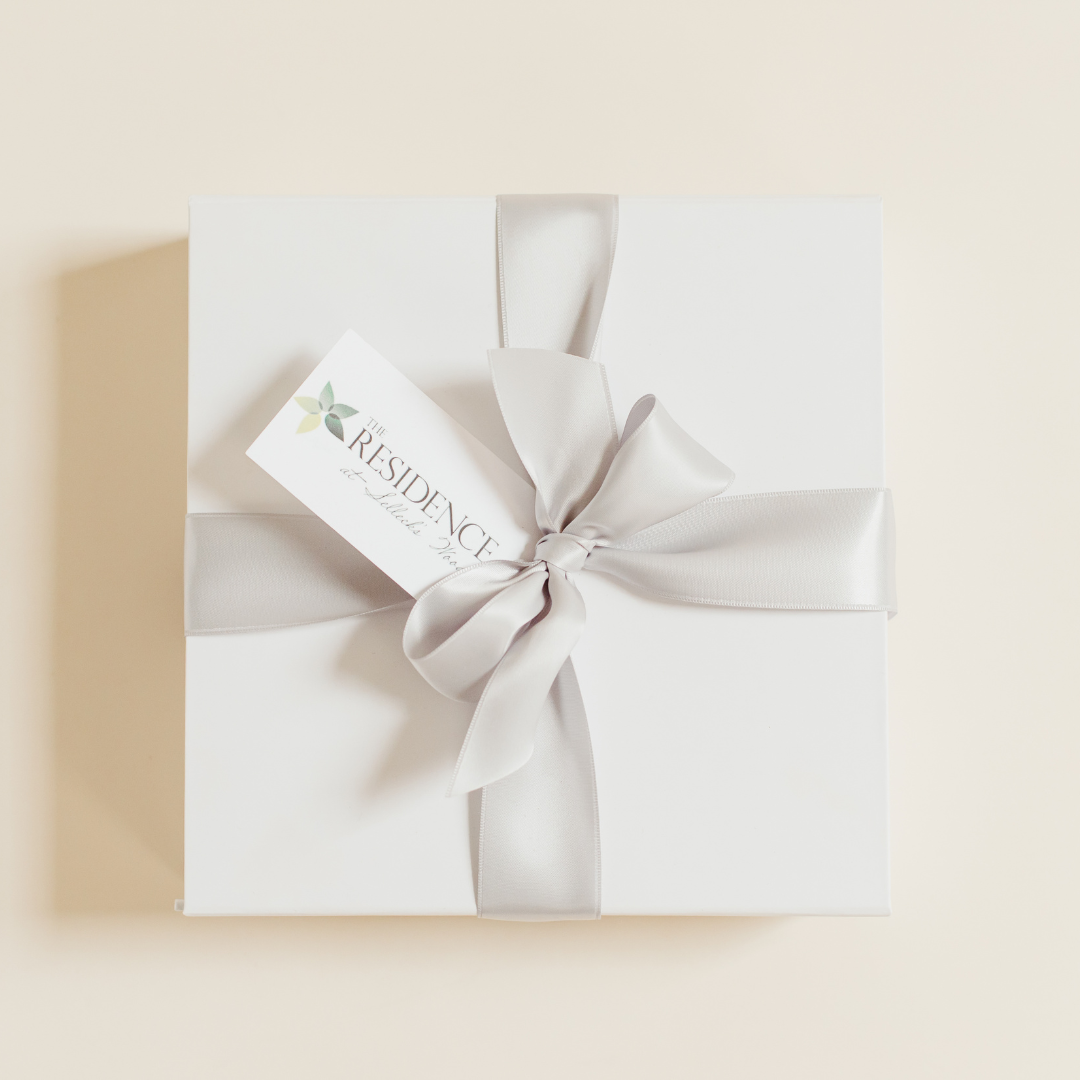 Elegant white corporate client gift box wrapped with ribbon and personalized gift tag