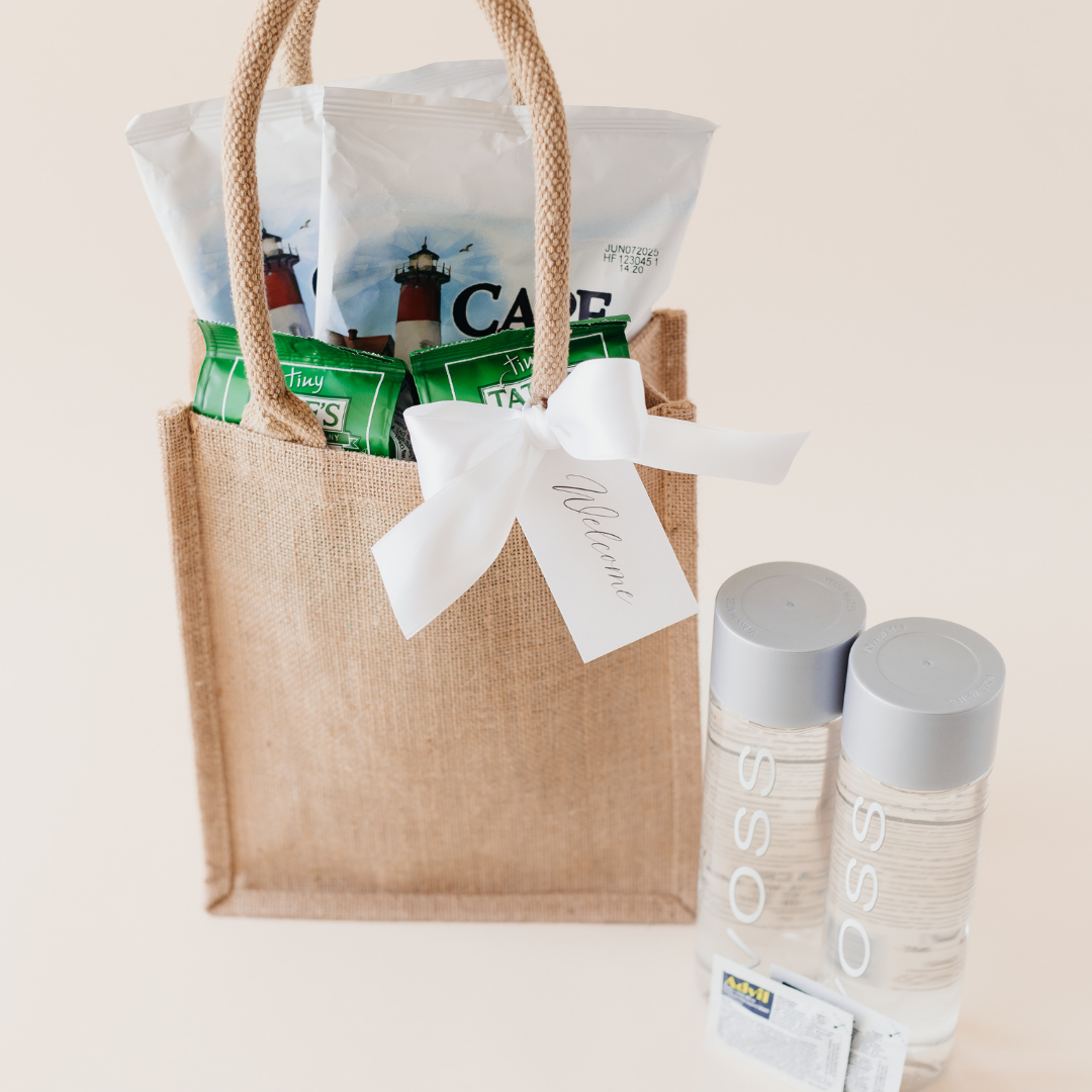 Custom hotel welcome gift bag with Cape Cod chips, Tate’s cookies, VOSS water, and a welcome tag - perfect for wedding or event guests