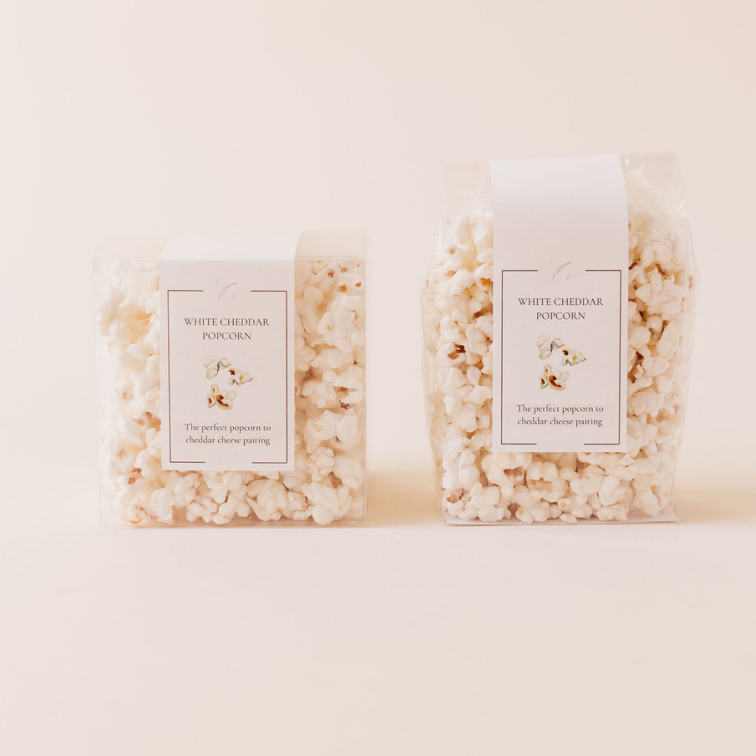 White cheddar popcorn party favors in clear packaging by Lavender + Pine, ideal for weddings, showers, and luxury events.