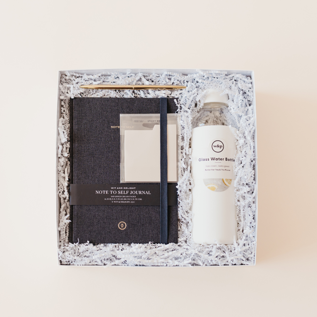 Semi-custom client gift box by Lavender and Pine featuring a Wit and Delight journal, glass water bottle, sticky notes, and gold pen