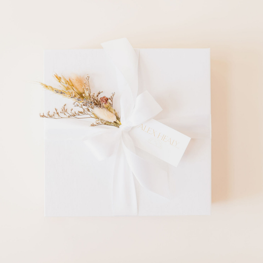 Luxury wedding client gift box with white ribbon and dried floral bundle, designed by Lavender + Pine.