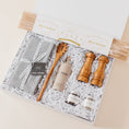 Load image into Gallery viewer, Lavender and Pine Cacio e Pepe Gift Box overhead angle featuring Bella Cucina bucatini pasta, Le Marké olive oil, Natural OliveWood salt and pepper mills, pasta spoon, La Boite grey salt and Tellicherry pepper, and Kaf Home grey linen napkins in white magnetic gift box

