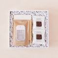Load image into Gallery viewer, Desk essentials corporate gift box with Touchland Beach Coco hand sanitizer, notepad, gold pen, and Rustic Bakery chocolate shortbread in a white box with crinkle paper.
