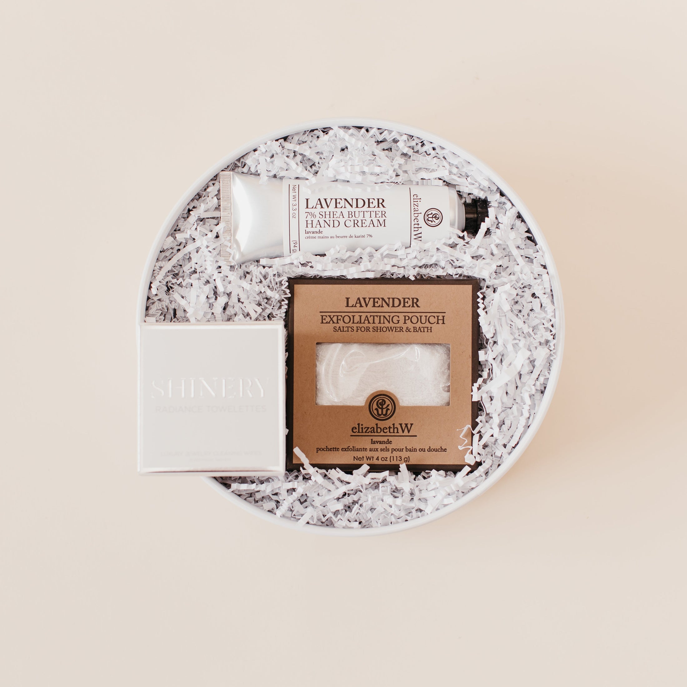 Lavender and Pine Love at First Site Gift Box featuring ElizabethW lavender shea butter hand cream, ElizabethW lavender exfoliating shower pouch, and Shinery radiance towelettes in white round gift box