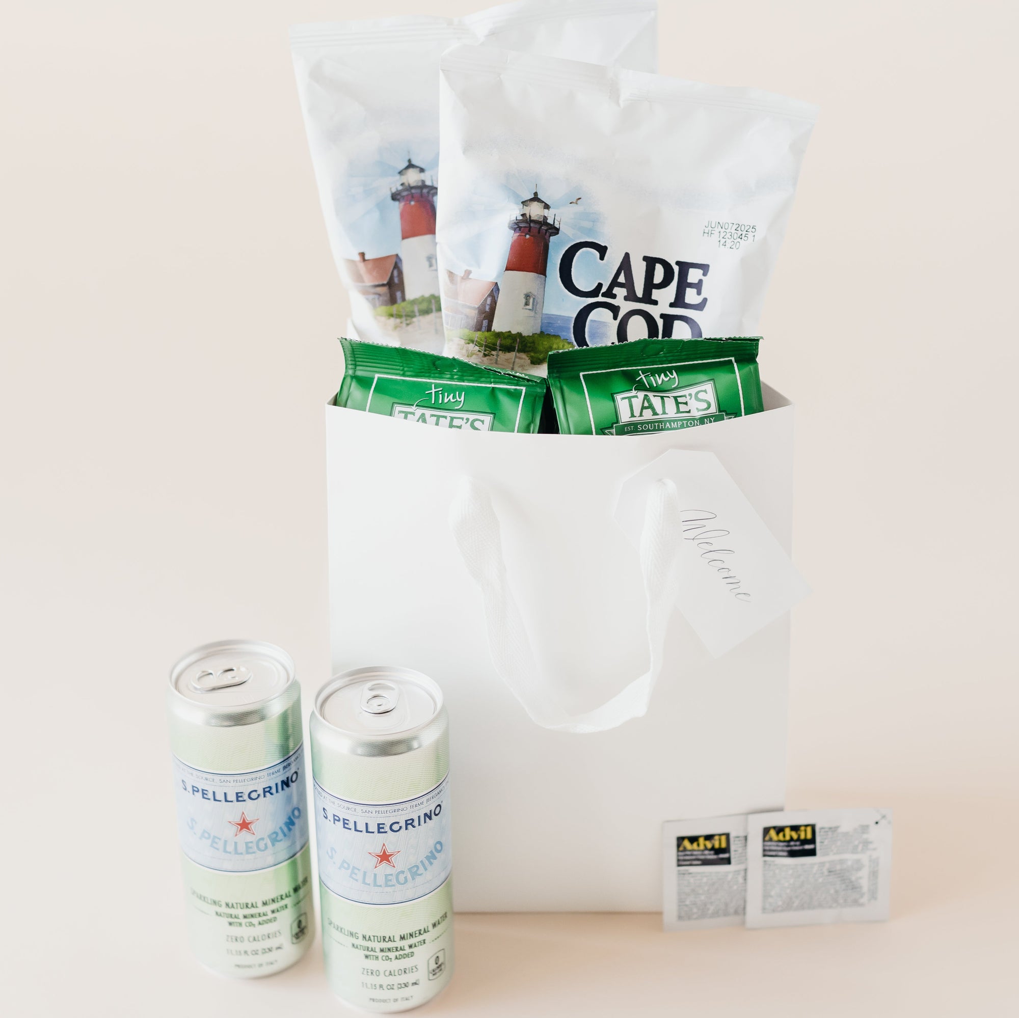 Classic Welcome gift set with bottled water, snacks, and travel essentials in a white gift bag