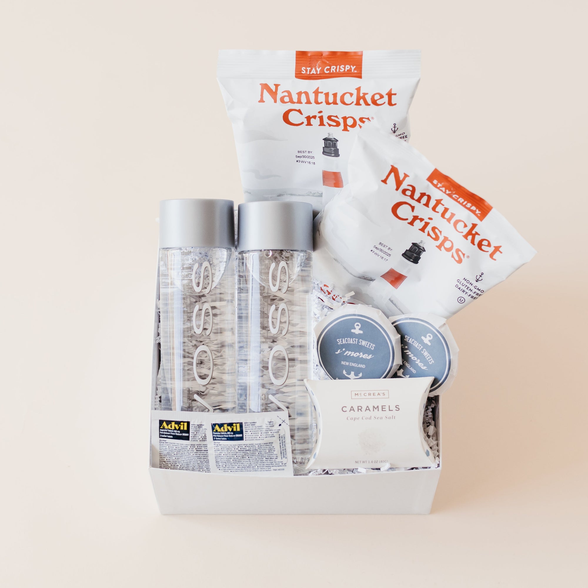 Snack gift box with VOSS bottled water, savory chips, sweet treats, and travel essentials