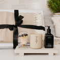 Load image into Gallery viewer, Lavender and Pine Sanctuary Gift Box styled view featuring Minot candle, Homecourt Neroli Leaf hand wash, black tip apothecary matches, Fennco Styles throw blanket, and Luxe B Co sandstone trivet riser in white magnetic gift box
