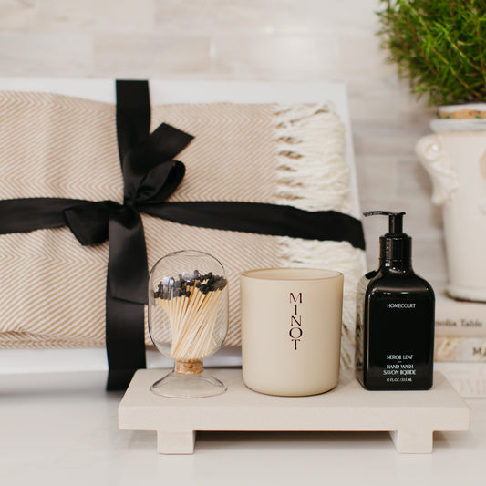 Lavender and Pine Sanctuary Gift Box styled view featuring Minot candle, Homecourt Neroli Leaf hand wash, black tip apothecary matches, Fennco Styles throw blanket, and Luxe B Co sandstone trivet riser in white magnetic gift box
