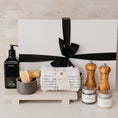 Load image into Gallery viewer, Lavender and Pine Well-Kept Kitchen Gift Box front view featuring Homecourt Cece dish soap, dish brush set, Monaco kitchen towels, Natural OliveWood salt and pepper mills, La Boite Tellicherry pepper and grey salt, and Luxe B Co sandstone trivet riser in white magnetic gift box.
